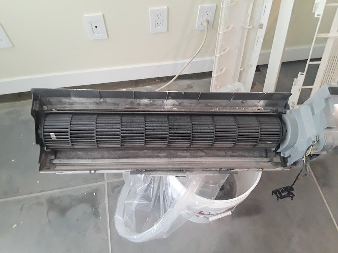 Close-up of a split air conditioner’s blower wheel and interior components exposed during a thorough cleaning